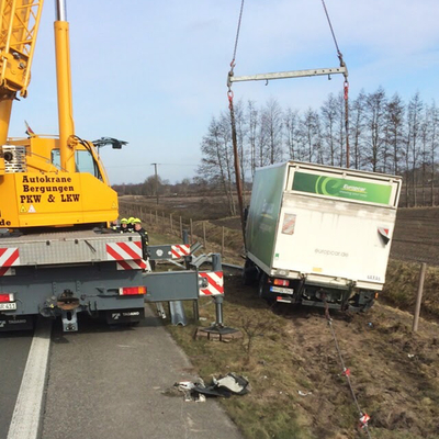 Gelber Rakel-Kran hebt ein Fahrzeug am Stra&szlig;enrand