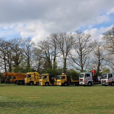 Abschlepp- und Servicefahrzeuge des Autohauses Rakel auf einer Wiese