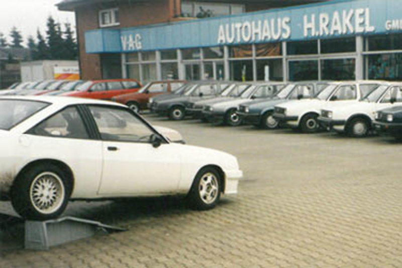 Historisches Autohaus Rakel mit Fahrzeugen vor dem Verkaufsgeb&auml;ude
