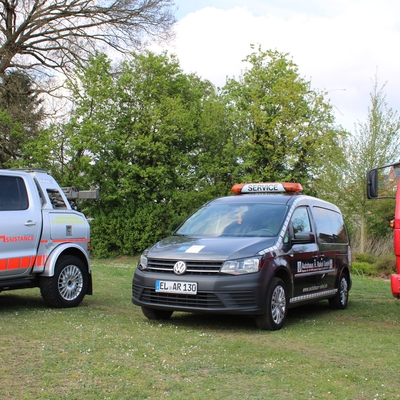Servicefahrzeuge des Autohauses Rakel auf einer Wiese